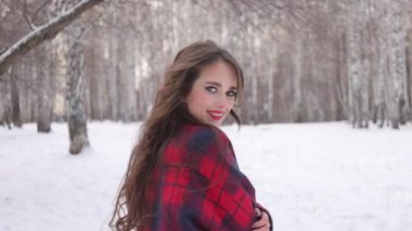 Karlı parkta karlı gömlekli bir kadın yürüyor.