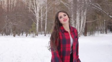 Karlı parkta karlı gömlekli bir kadın yürüyor.