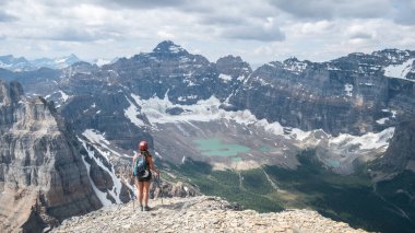 Kanada 'nın Kanada Rocky Dağları' ndaki Mount Temple 'ın zirvesinden alp manzarasının keyfini çıkaran kadın yürüyüşçü