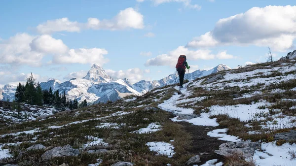 Backcountry hiker walking towards mountains on a sunny day, Mt Assiniboine Provincial Park, Canada