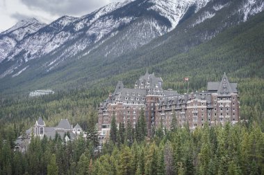 Dağların altındaki bir ormanda lüks bir dağ oteli, dar bir açı, Banff, Kanada.