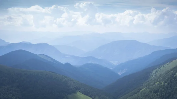 Güneşli bir günde, Slovakya, Avrupa 'da yeşil kıvrımlı tepelerin kaybolduğu manzara.