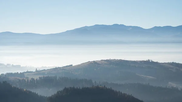 Autumnal landscape with misty forests and foggy mountains in background, Slovakia, Europe.