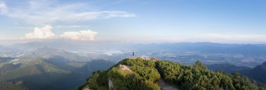 Dağın tepesinde dikilen ve altındaki vadiden, Slovakya 'dan, Avrupa' dan manzaranın keyfini çıkaran bir adam..