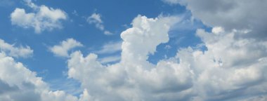 Mavi gökyüzü arka planında güzel kabarık bulutların panoramik görüntüsü