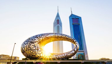 Dubai, BAE, 23 Kasım 2021: Geleceğin Dubai Müzesi ve Emirates Kuleleri Oteli, sabah veya gün doğumunda. Dubai 'nin ikonik binası. Dış görünüşünde Arap şiiriyle.