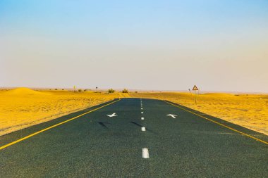 Dubai Birleşik Arap Emirlikleri 'ndeki Issız Çöl Yolu. Yol kumla kaplı..