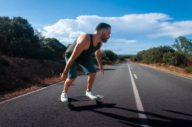 young man with skateboard, man on surf skate, surfing the highway, in a small town , nature