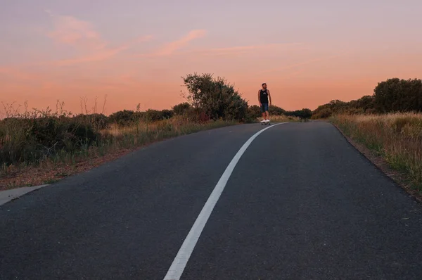 young man with skateboard, man on surf skate, surfing the highway, in a small town , nature
