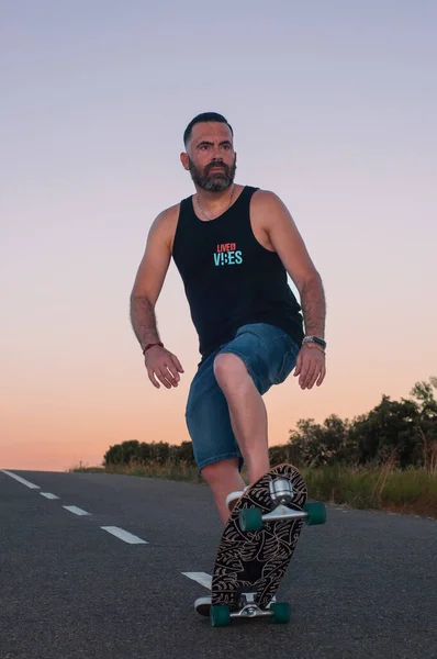 young man with skateboard, man on surf skate, surfing the highway, in a small town , nature