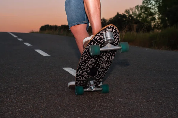 young man with skateboard, man on surf skate, surfing the highway, in a small town , nature