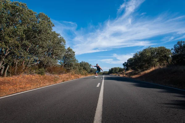 young man with skateboard, man on surf skate, surfing the highway, in a small town , nature