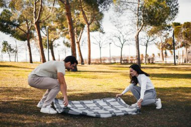 Genç İspanyol çift, arkadaşlıklarının tadını çıkarmak için piknik kıyafeti giyiyorlar.