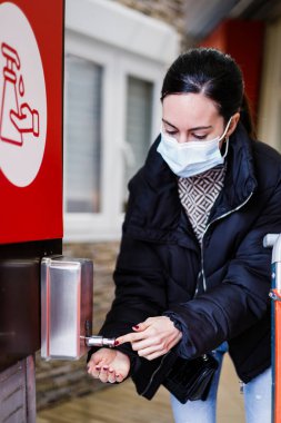 Coronavirus salgını sırasında dükkanın girişinde hidroterapi jeli kullanan bir kadın..