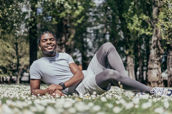 Çiçekli bir parkta Afro-Amerikalı eşcinsel bir genç adam.