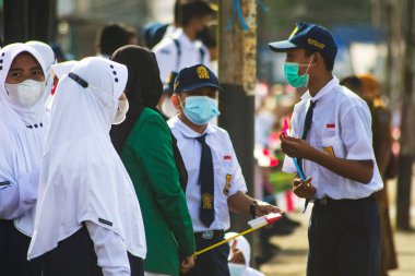 Sorong, Batı Papua, Endonezya, 4 Ekim 2021. Endonezya Başkanı Joko Widodo 'nun resmi ziyareti. Okul çocukları ve öğretmenleri, Başkan 'ın yol kenarından gelişini memnuniyetle karşıladılar..