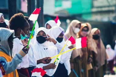 Sorong, Batı Papua, Endonezya, 4 Ekim 2021. Endonezya Başkanı Joko Widodo 'nun resmi ziyareti. Okul çocukları ve öğretmenleri, Başkan 'ın yol kenarından gelişini memnuniyetle karşıladılar..