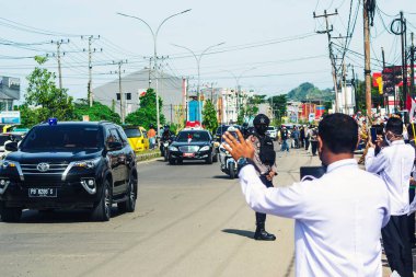 Sorong, Batı Papua, Endonezya, 4 Ekim 2021. Endonezya Başkanı Joko Widodo 'nun resmi ziyareti. Okul çocukları ve öğretmenleri, Başkan 'ın yol kenarından gelişini memnuniyetle karşıladılar..