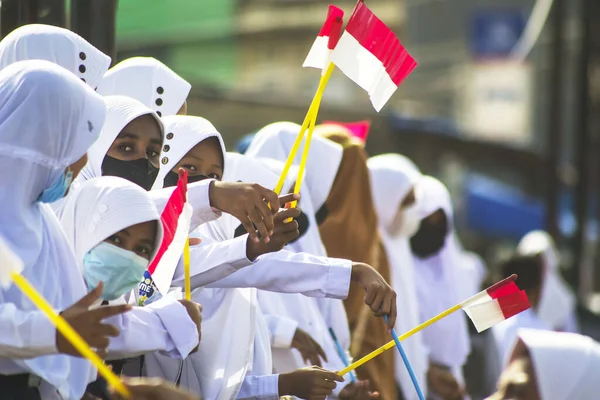 Sorong, Batı Papua, Endonezya, 4 Ekim 2021. Endonezya Başkanı Joko Widodo 'nun resmi ziyareti. Okul çocukları ve öğretmenleri, Başkan 'ın yol kenarından gelişini memnuniyetle karşıladılar..