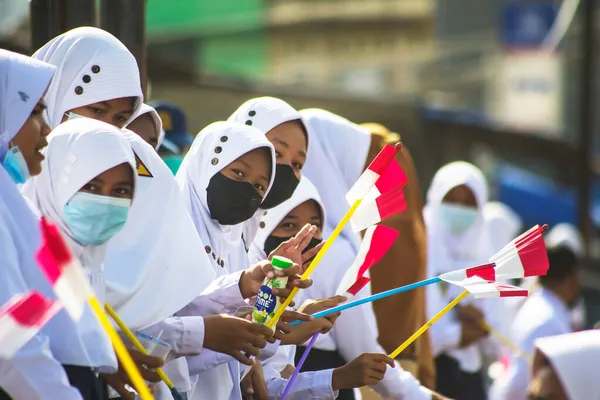 Sorong, Batı Papua, Endonezya, 4 Ekim 2021. Endonezya Başkanı Joko Widodo 'nun resmi ziyareti. Okul çocukları ve öğretmenleri, Başkan 'ın yol kenarından gelişini memnuniyetle karşıladılar..