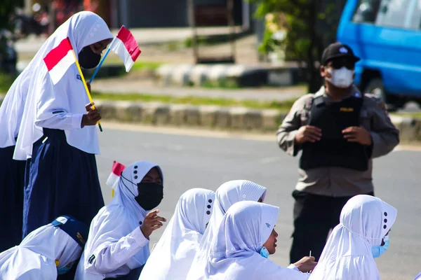 Sorong, Batı Papua, Endonezya, 4 Ekim 2021. Endonezya Başkanı Joko Widodo 'nun resmi ziyareti. Okul çocukları ve öğretmenleri, Başkan 'ın yol kenarından gelişini memnuniyetle karşıladılar..