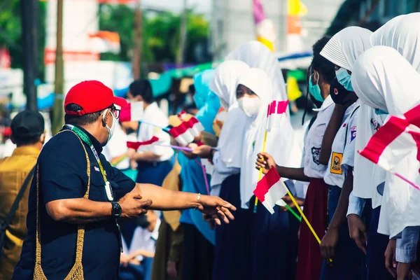 Sorong, Batı Papua, Endonezya, 4 Ekim 2021. Endonezya Başkanı Joko Widodo 'nun resmi ziyareti. Okul çocukları ve öğretmenleri, Başkan 'ın yol kenarından gelişini memnuniyetle karşıladılar..