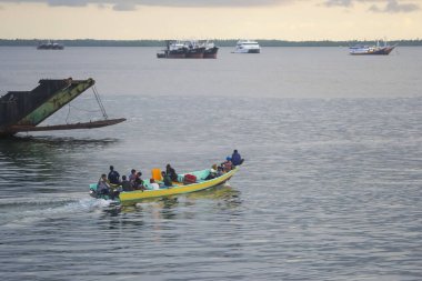 Sorong, Batı Papua, Endonezya, 30 Eylül 2021. Köylüler geleneksel ahşap teknelerle sorong sularını geçiyorlar.
