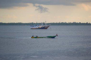 Sorong, Batı Papua, Endonezya, 30 Eylül 2021. Köylüler geleneksel ahşap teknelerle sorong sularını geçiyorlar.