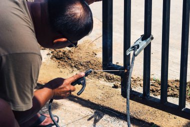 Sorong, Batı Papua, Endonezya, 6 Kasım 2021. Bir işçi eldiven takmadan demir kaynaklıyor. Hafif kaynak çalışması.