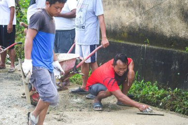 Sorong, Batı Papua, Endonezya, 7 Kasım 2021. Köylüler hasarlı köy patikalarını onarmak için birlikte çalışırlar. Mahalle şefi tarafından yönetilen toplumsal iş geleneği.