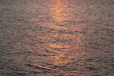 Deniz üzerinde gün batımı gökyüzü. Deniz manzarası, kayalık sahil ve ada.