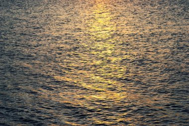 Deniz üzerinde gün batımı gökyüzü. Deniz manzarası, kayalık sahil ve ada.