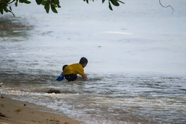 Sorong, Batı Papua, Endonezya, 12 Aralık 2021. Çocuklar sahilde dalgalara karşı oynuyorlar.