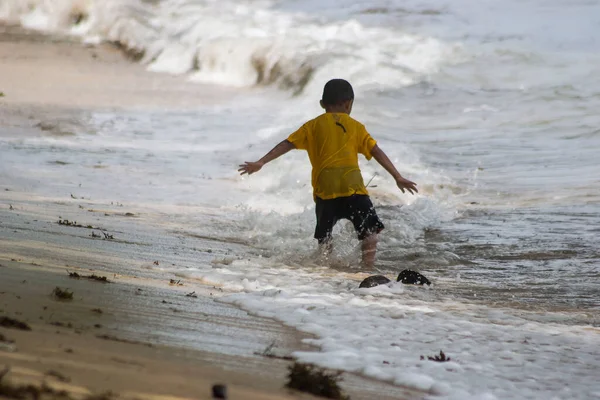 Sorong, Batı Papua, Endonezya, 12 Aralık 2021. Çocuklar sahilde dalgalara karşı oynuyorlar.