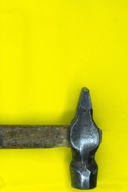 Demir çekiç, sarı arka planda fotoğraf.