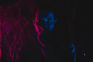 Arka planda arka lambalı bir adam, gece çekilmiş bir fotoğraf.