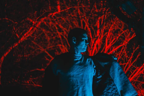 Arka planda arka lambalı bir adam, gece çekilmiş bir fotoğraf.