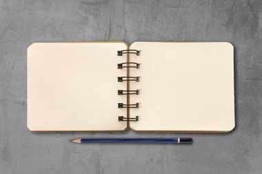 Beton duvar yüzeyine yerleştirilmiş defter ve kalem. Not defteri konsepti.