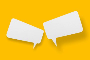 Konuşma baloncuğu şeklinde beyaz kağıt sarı arka plana ayarlandı. İletişim baloncukları.