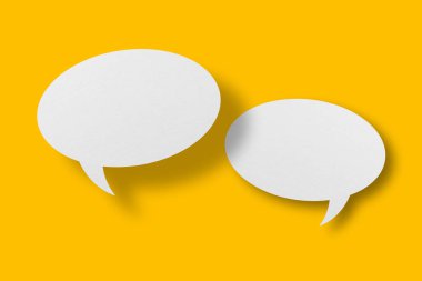 White paper in speech bubble shape set against yellow background.Communication bubbles.