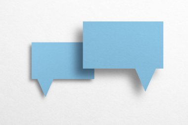 Konuşma balonu şeklindeki mavi kağıt beyaz arka planda izole edilmiş. iletişim baloncukları