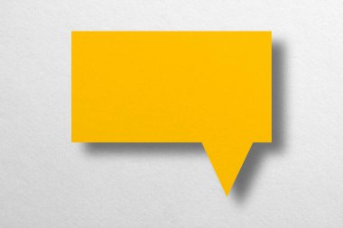 Beyaz arkaplan haberleşme balonlarında izole edilmiş konuşma balonu şekilli sarı kağıt.