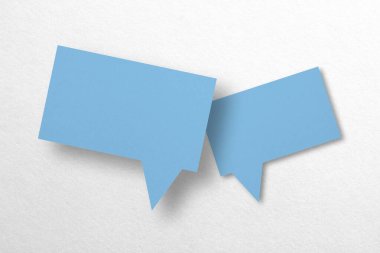 Konuşma balonu şeklindeki mavi kağıt beyaz arka planda izole edilmiş. iletişim baloncukları