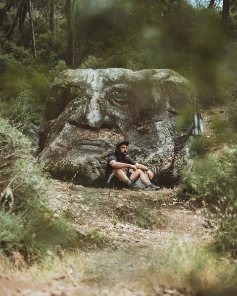 Yorgun bir gezgin kayanın dibinde su içiyor.