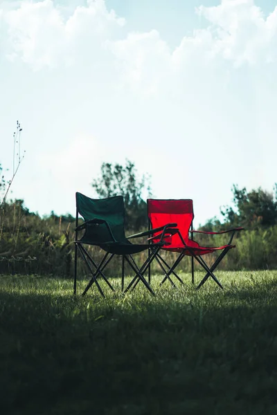 İki kamp koltuğu yan yana kırmızı ve mavi