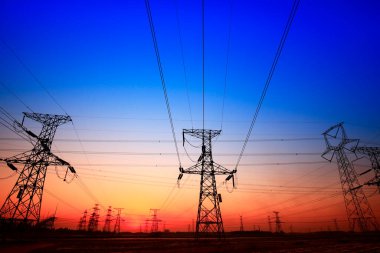 Gün batımında yüksek voltaj kuleleri