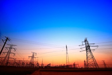 Gün batımında yüksek voltaj kuleleri