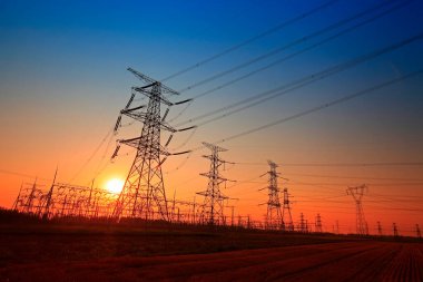 Gün batımında yüksek voltaj kuleleri