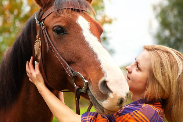 Hermosa joven rubia con un caballo, retrato. — Foto de Stock