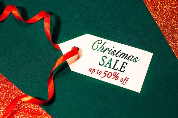 テキスト付き割引ラベル エメラルドグリーンの背景に赤いリボンで50オフ 白までのクリスマス販売 クリスマスと新年のコンセプト — ストック写真